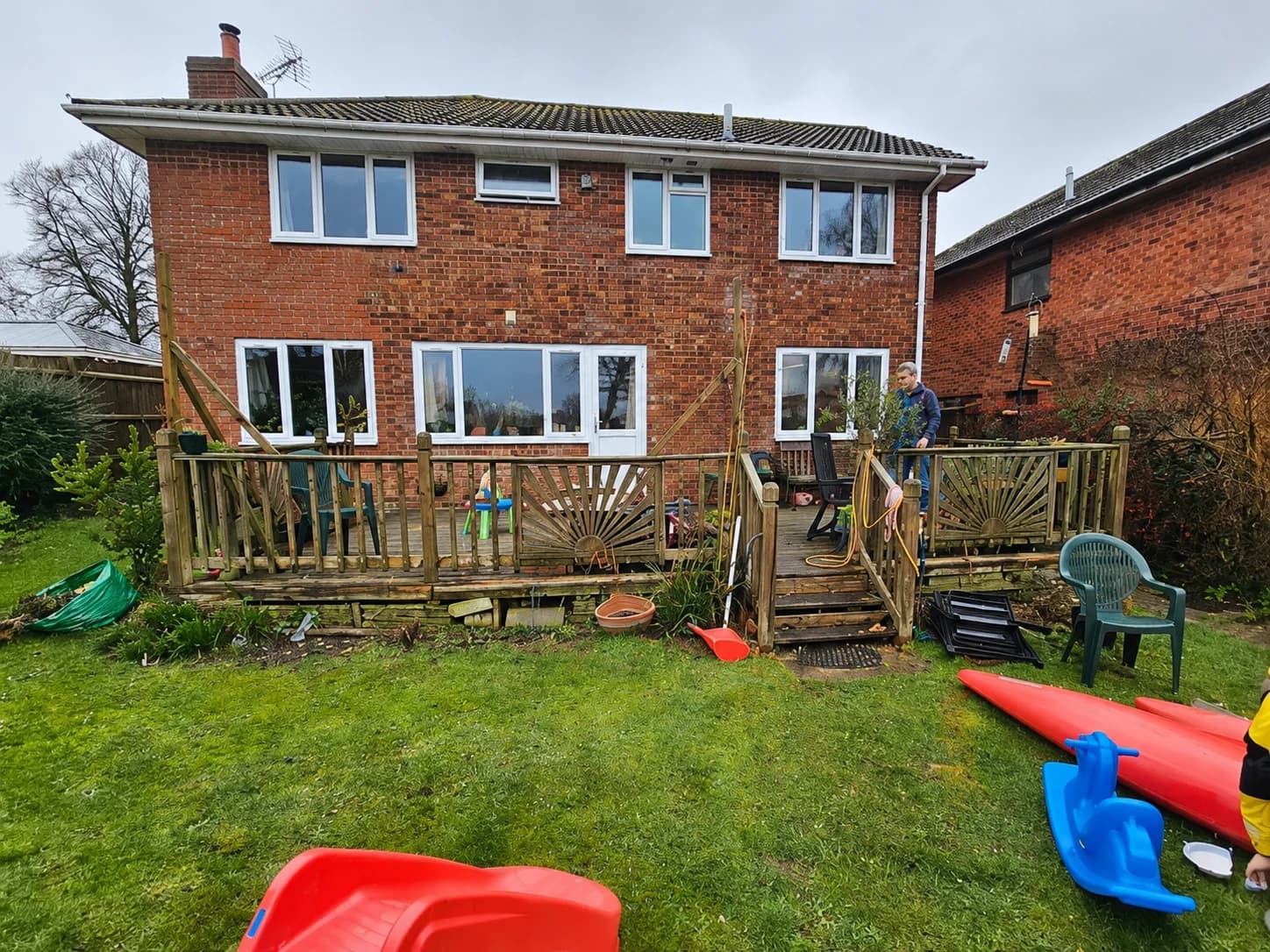 Before: the original worn timber deck and railings across the back of the house